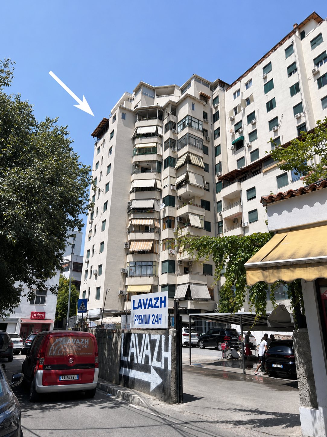 The apartment building seen from the parking area, marked with an arrow