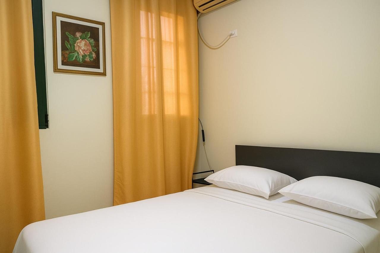 Double bedroom at The Prism with crisp white linens and golden curtains