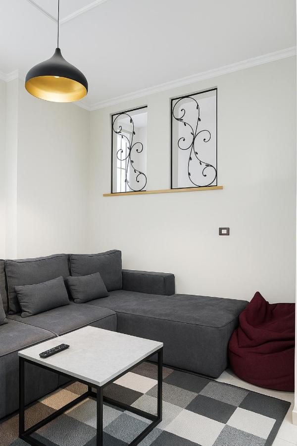 Grey corner sofa and coffee table in the living room of The Prism apartment, Tirana