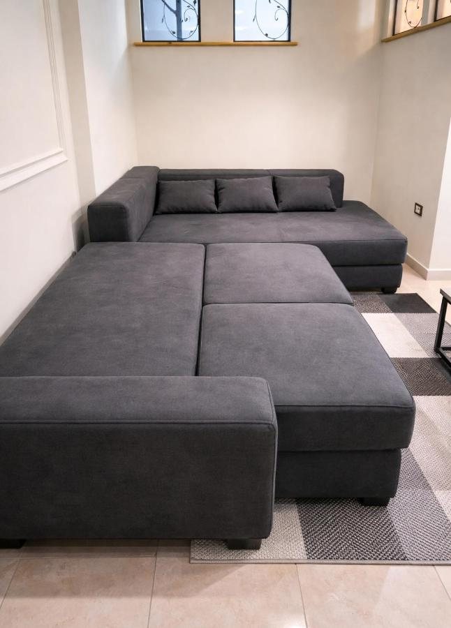 Grey sectional sofa that converts to an extra bed at The Prism apartment